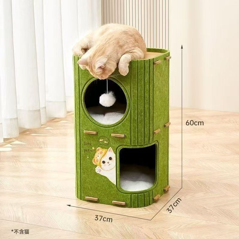 A modern, cylindrical cat tree tower made of green felt material, measuring 60cm in height and 37cm in width and depth. It features multiple levels including a top platform where a ginger cat is lounging, a middle circular window with a hanging white pom-pom toy, and a bottom arched entrance with a soft cushion. The front panel is decorated with a cute cartoon cat decal reading 'Cute pet'. Dimensions: 60cm (H) x 37cm (W) x 37cm (D). Cat not included.