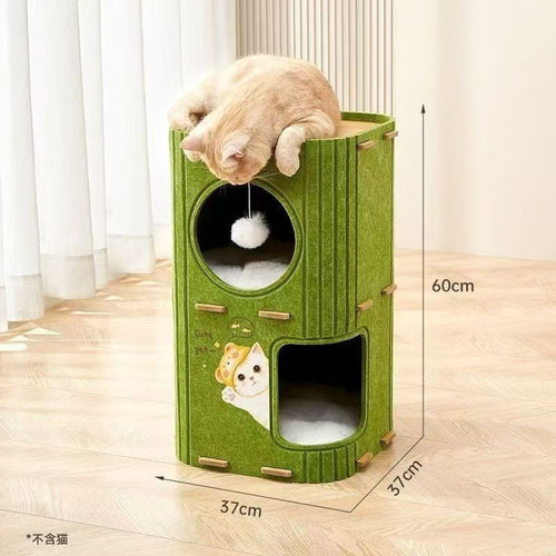 A modern, cylindrical cat tree tower made of green felt material, measuring 60cm in height and 37cm in width and depth. It features multiple levels including a top platform where a ginger cat is lounging, a middle circular window with a hanging white pom-pom toy, and a bottom arched entrance with a soft cushion. The front panel is decorated with a cute cartoon cat decal reading 'Cute pet'. Dimensions: 60cm (H) x 37cm (W) x 37cm (D). Cat not included.