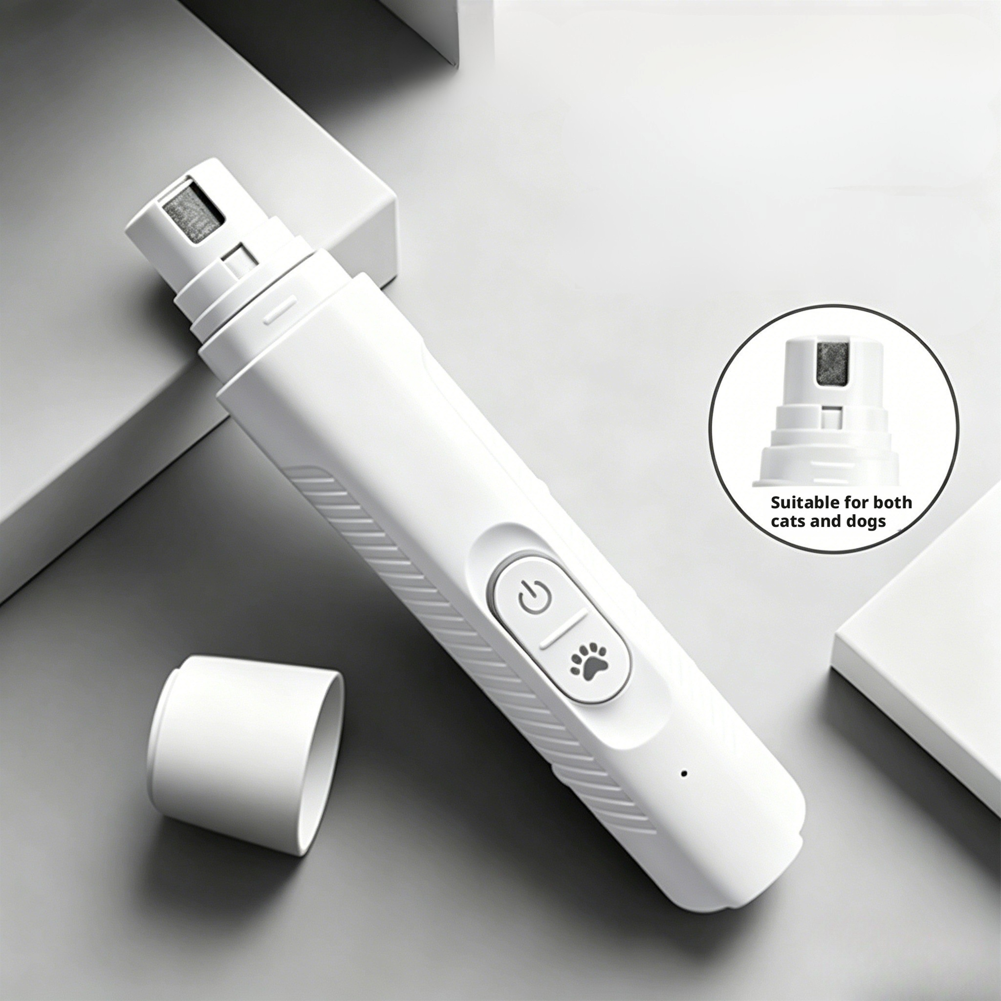 White electric pet nail grinder suitable for both cats and dogs. Features a power button and paw-print function key, with a detachable safety grinding head (shown in close-up). Designed for low-noise operation to reduce pet anxiety, USB rechargeable for portability, and anti-slip grip for secure handling during grooming sessions. Ideal for home pet care to trim claws safely without hurting paws.